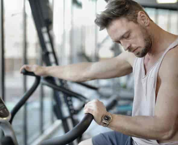 man tired resting on gym machine: does mk-677 improve sleep quality