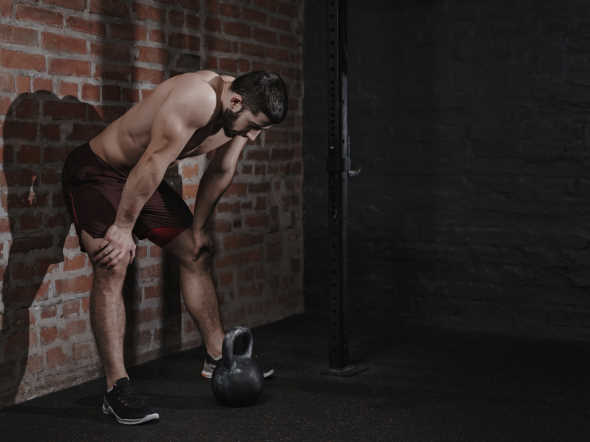 athlete is leaning against the wall at the gym suffering anxiety
