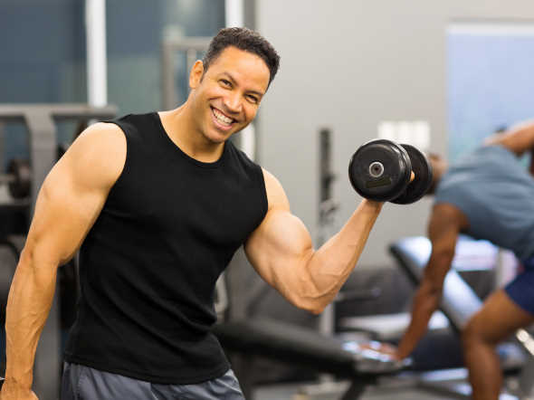  happy bodybuilder lifting dumbbells in gym anxiety free