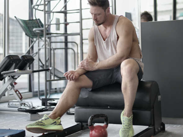 tired male athlete resting on bench 